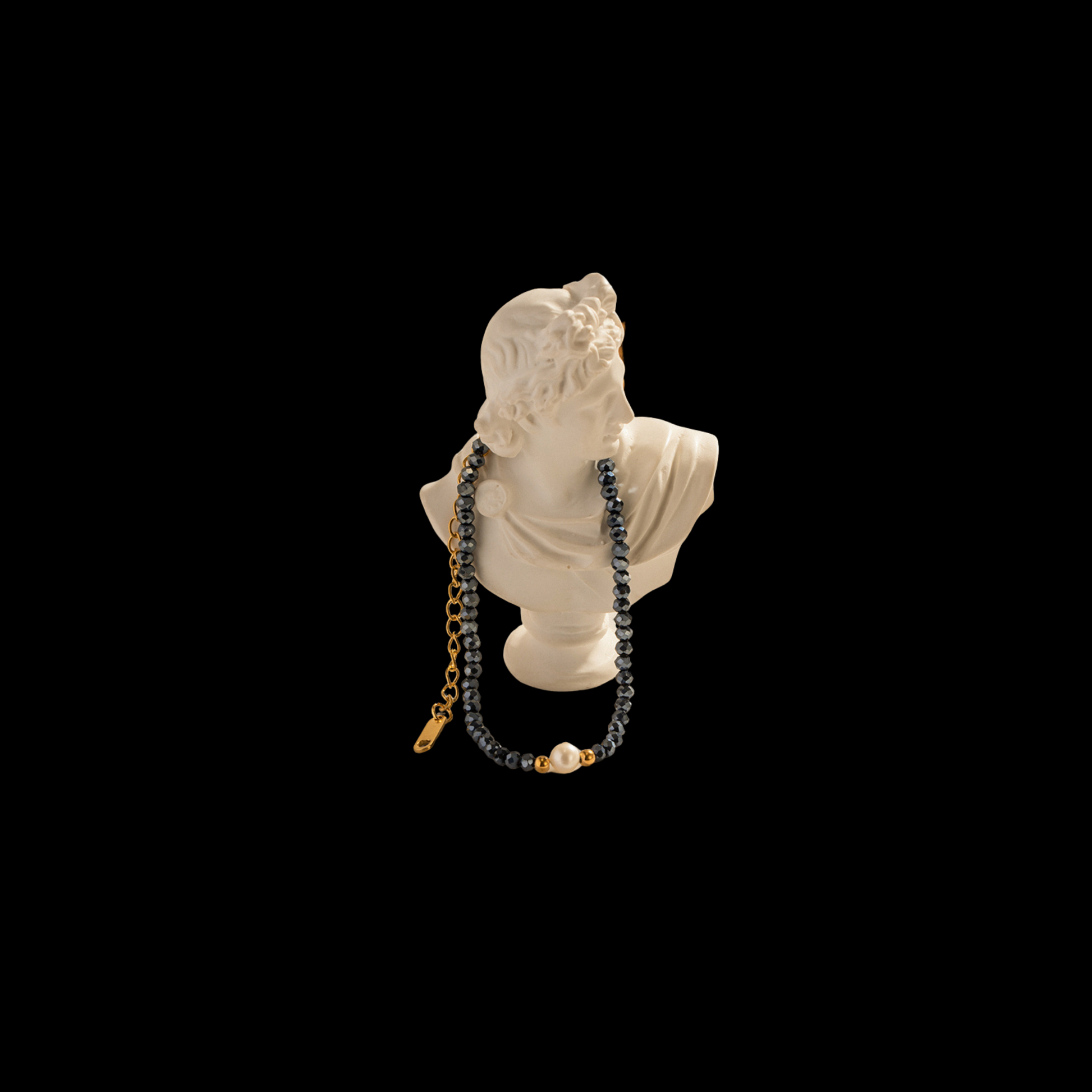 Necklace displayed on a classical bust against a black background